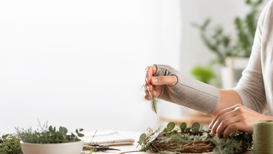 Adult wearing a wrist and thumb support while arranging greenery